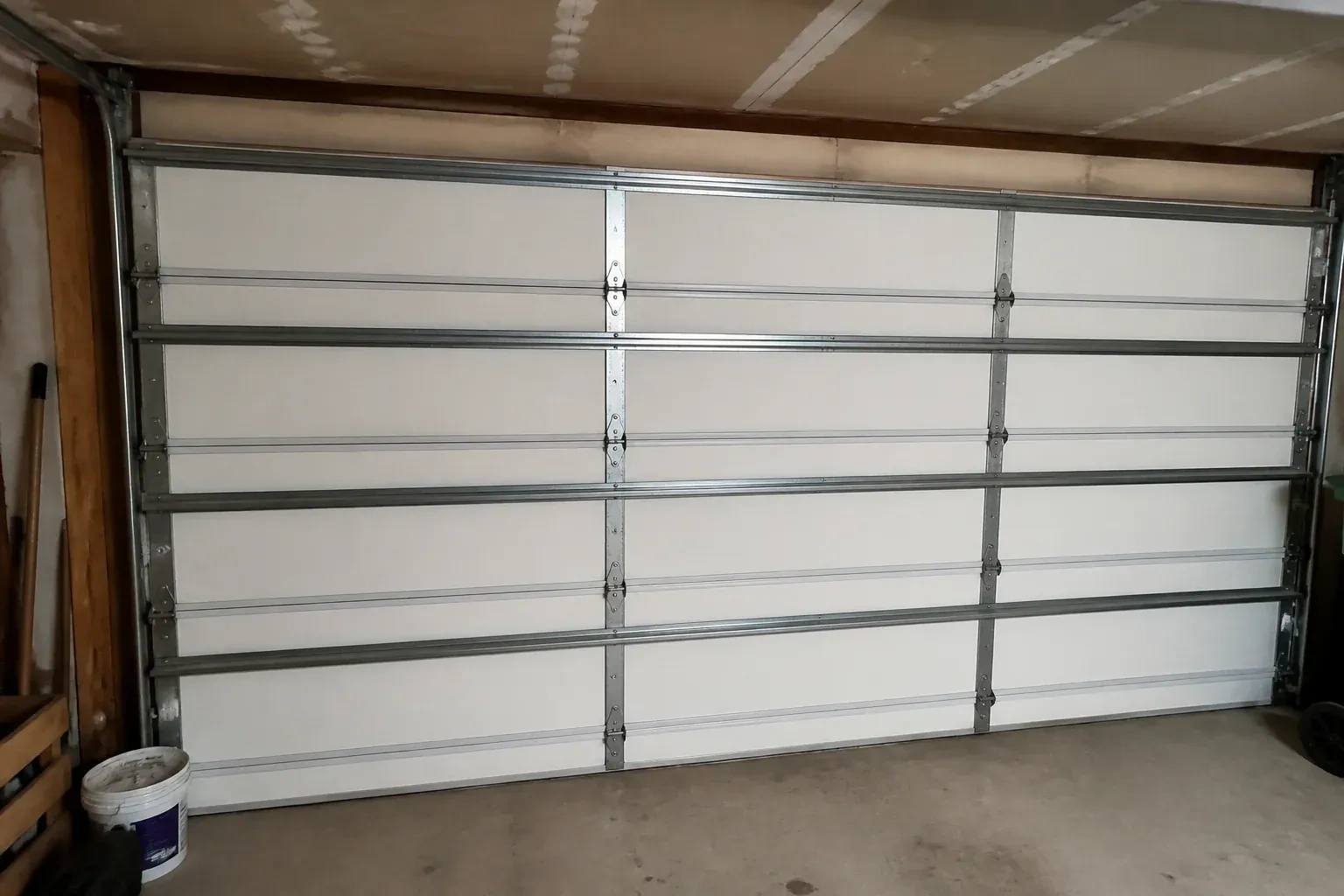Interior of a closed sectional door with horizontal metal reinforcement struts. — Wind-Rated Garage Door Replacement, Orillia